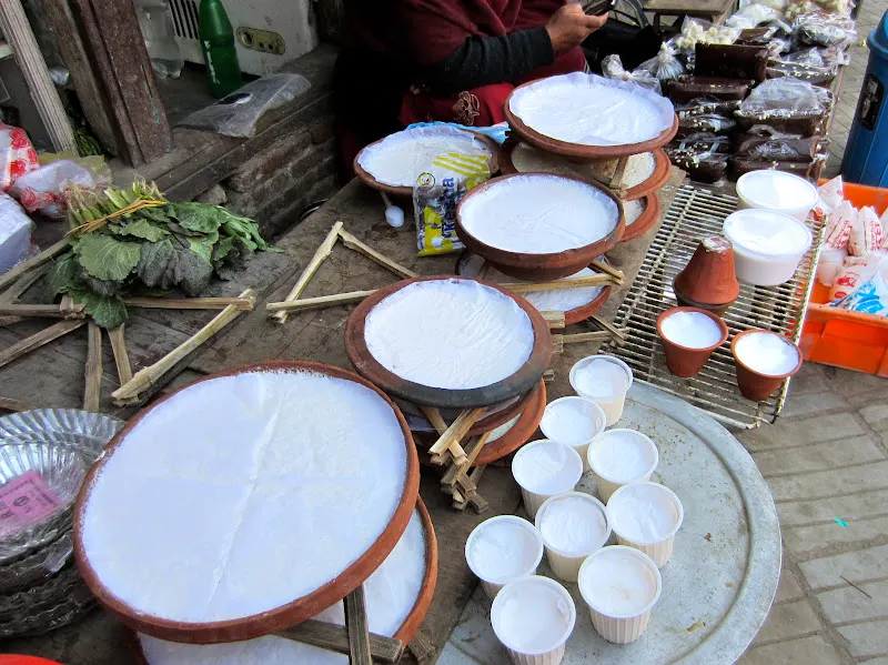 Maru Tole open market - at the southwestern corner of the Kathmandu Durbar Square. morning shopping - different containers of Juju Dhau.