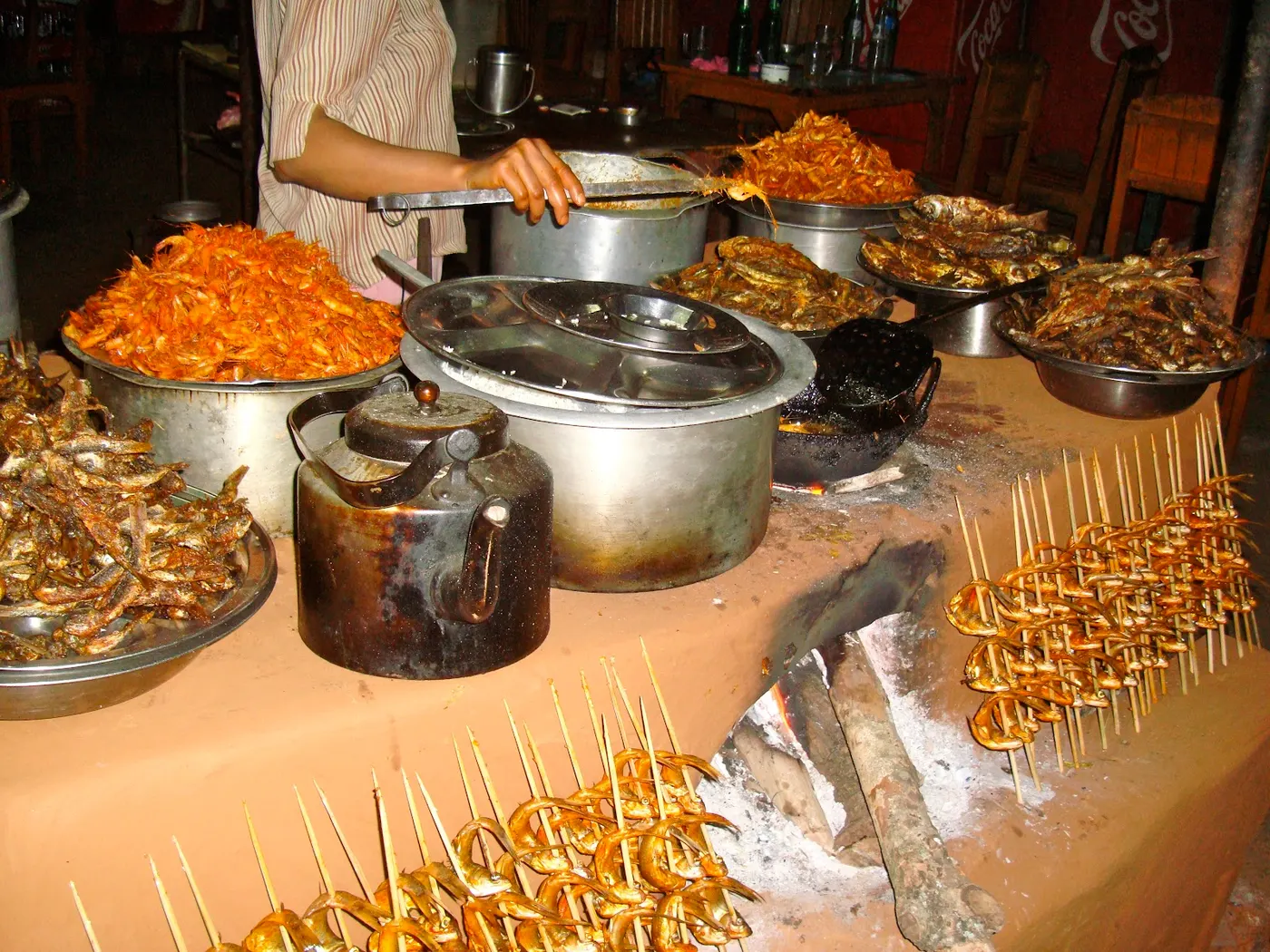Small fish are woven in bamboo skewers, and then are placed in an upright position next to the wood-burning stove to make maachaa ko sukuti (dried fish).