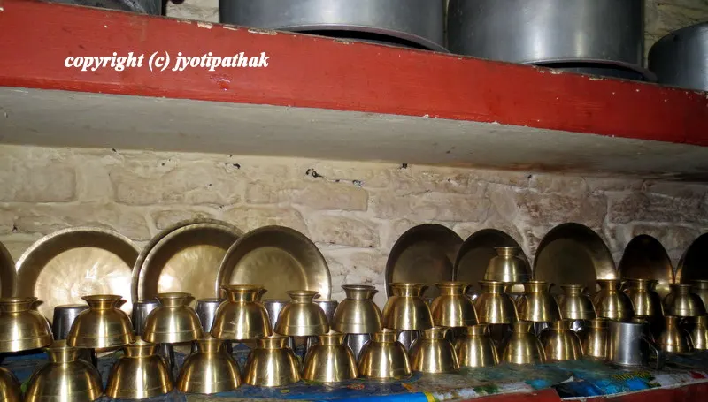 Shelves full of Nepali bhaadaa-kudaa (Nepali utensils) line the wall at the cozy restaurant.