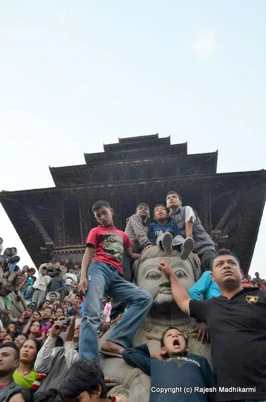 ... spectators watching Bisket Jatra - young children climbing on a statue ...