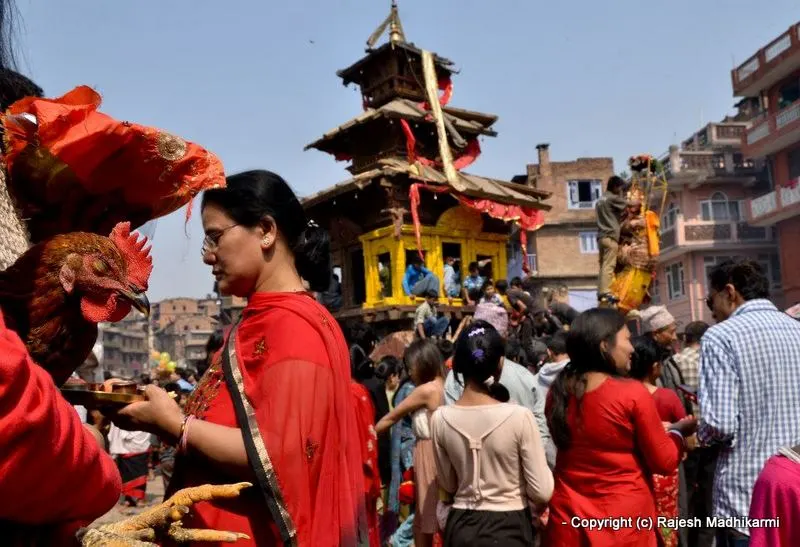 ... the lady in the red is carrying a tray full of offerings for the deity ...