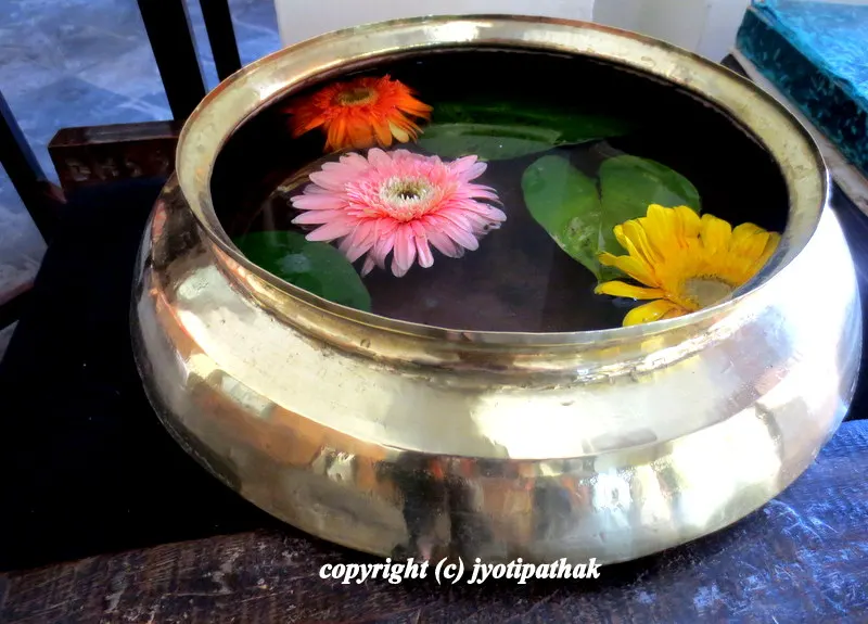 ... attractive display of floating spring flowers in a freshly shined brass pot. It is kept in the hallway of a hotel for a warm welcome and cheer.