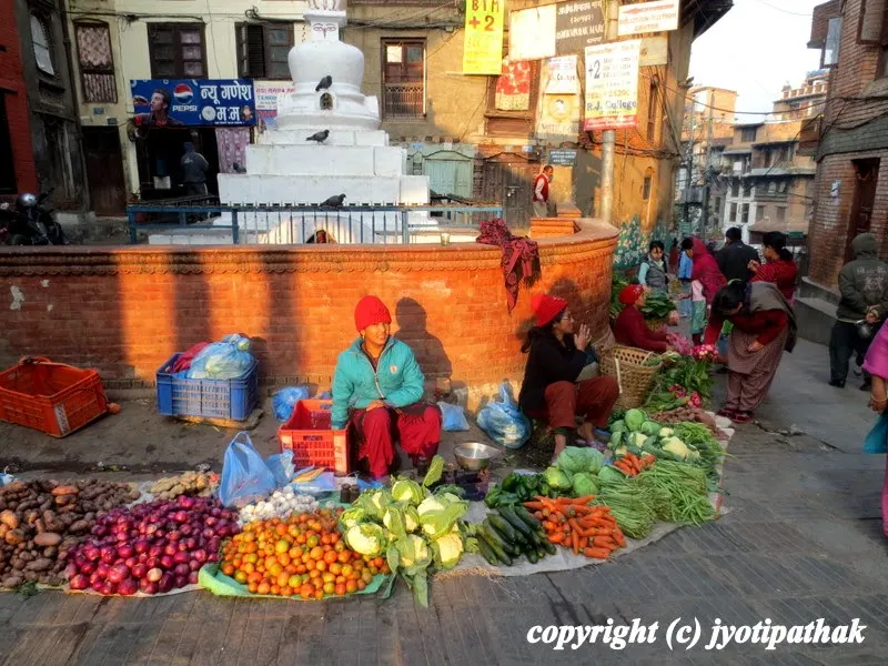 Busy Kathmandu streets - images of several varieties of fresh vegetables and the vendors are waiting on the customers