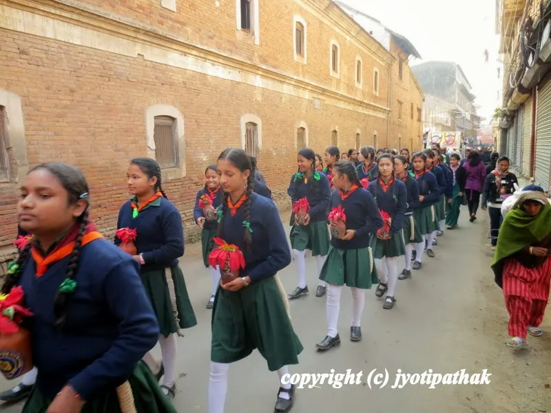 A group of young girl scouts marching in the street during festival time