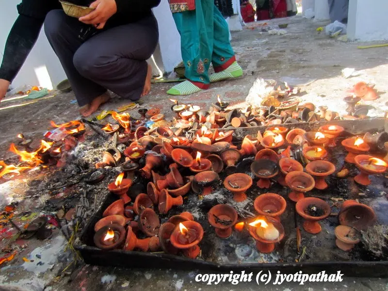 Oil fed lamp (diyo) in front of a temple