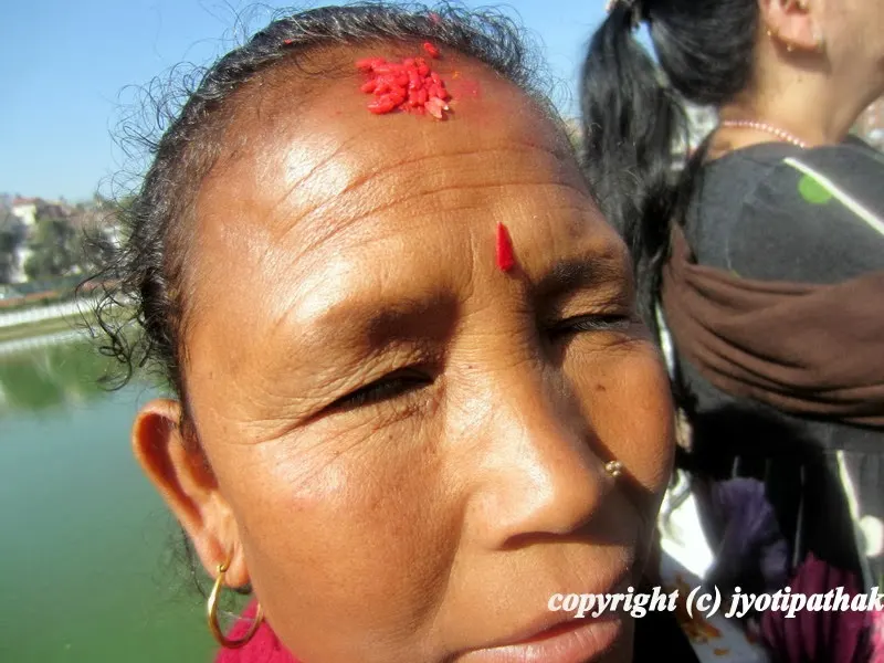 A women from the middle hills is happy to be photographed, and proudly showing me her Dashain ko auspicious Tikaa.
