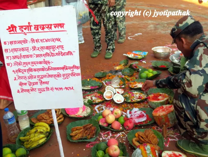 Religious ceremony before and after the ceremonial slaughter - an army official checks the ash gourd (kubhindo) and fresh coconut cut into two pieces offered to deities
