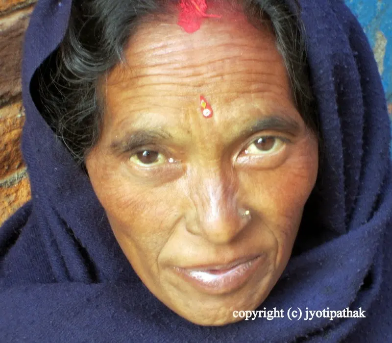 A women from the middle hills is happy to be photographed, and proudly showing me her Dashain ko auspicious tikaa.