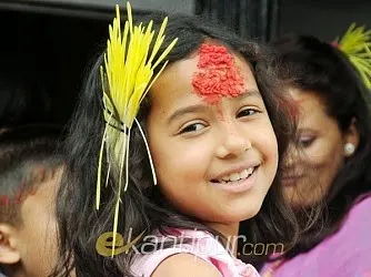 A happy young girl with large tikaa in her forehead - notice her jamaraa is carefully secured with a hair pin - photo credit - ekantipur