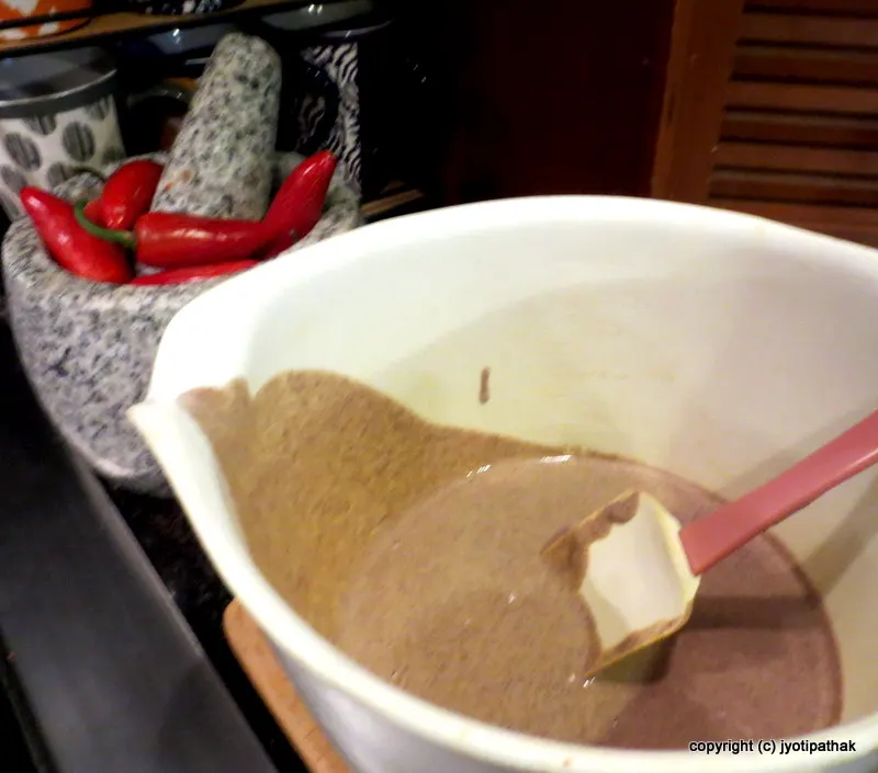 Getting ready to make phaapar ko roti - whisking together all the ingredients until there is no lump, making sure it is semi-thick consistency and should spread evenly when poured on the griddle.